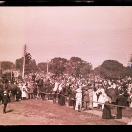 Public gathering at Hyde Park, Australian Museum on left at corner of Park and College Streets, Sydney NSW, c.1914