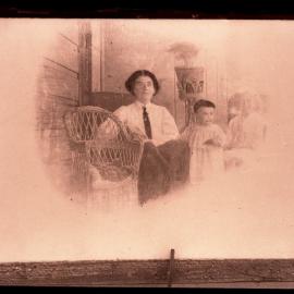 Woman dressed in shirt and tie, with children