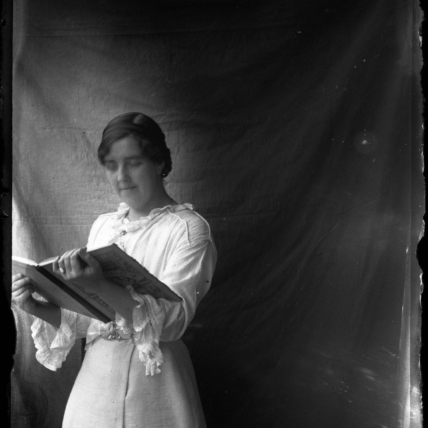 Unidentified woman holding an open book, c1910s