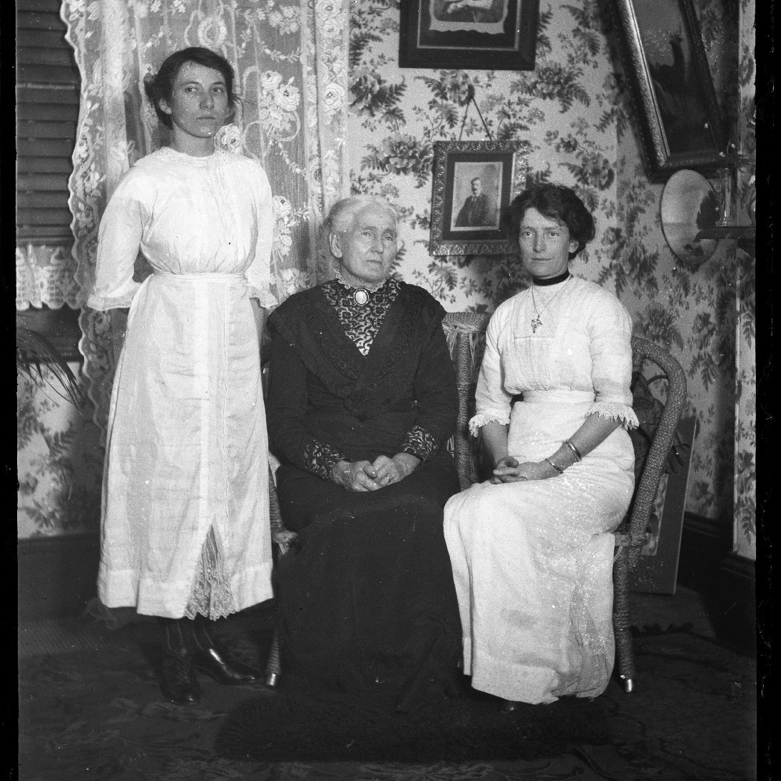 Three unidentified women in sitting room, c1910s