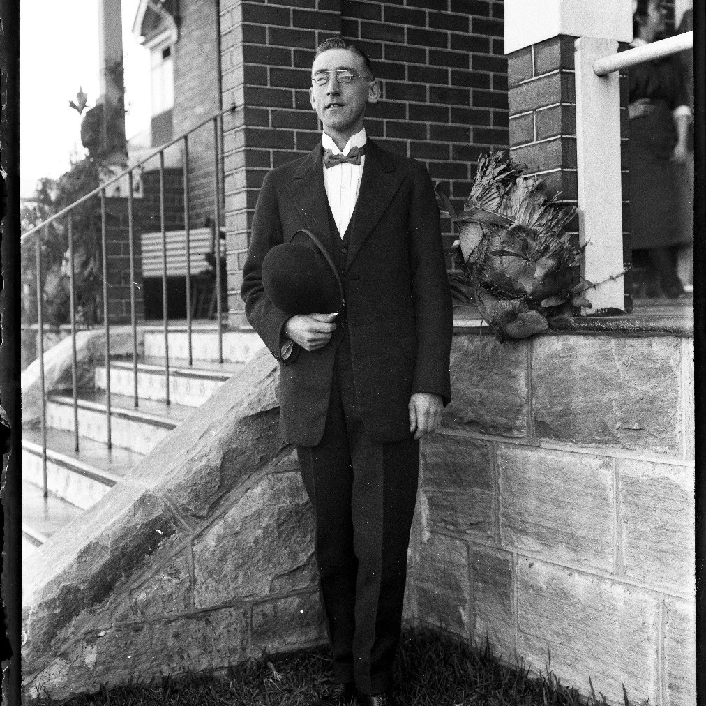 Unidentified man in suit, hat and neck tie.