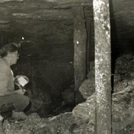 Old East Maitland series mine workings found by Bloomfield No 4 Colliery, 1967. View at point of breakin. Note that while the official has an electric-cap lamp, he is using a flame-safety lamp to detect noxious gases which might emit from the old workings