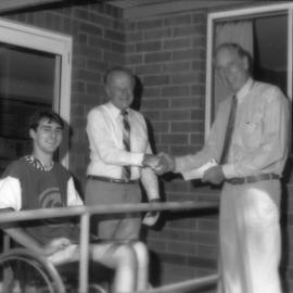 Keith Barbour (Friends of the University) hands over a cheque to John Peschar while Grant Nickel looks on, the University of Newcastle, Australia - April, 1992