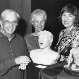 Krysten Walker (r) with two unidentified people examining her Sculpture artworks, the University of Newcastle, Australia