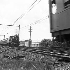 NSWGR C-35 Class No. 3506 4-6-0 Type Express Passenger Locomotive hauling the "Caves Express" near Lidcombe passing Sydney bound suburban electric train, [1930s]