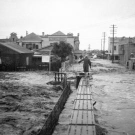 Person balancing on [fence?] during the Maitland Flood, 1955: Lucey Collection