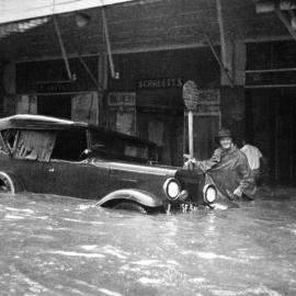 Partly submerged car outside Scarletts and Kay [Henry] stores during the Maitland Flood, 1955: Lucey Collection