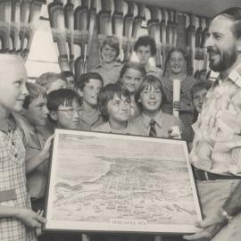 Dr. John Turner presents a lithograph of Newcastle in 1874 to Anissa Lockwood.