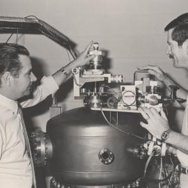 Professor Ron MacDonald and Dr. John O'Connor, working with an apparatus used for the location of atoms on surfaces by low energy ion scattering: the University of Newcastle, Australia