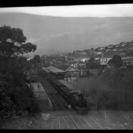 NSWGR C30 Class, No. 3079, hauling coal hoppers past station platforms, unidentified location, [n.d.]