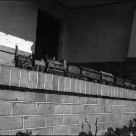 Model locomotives, image 3 of 3, showing a 0-2-2 and a 0-6-0 with passenger carriages, unknown date and location.