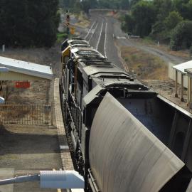 Three ninety class locomotives lead a coal train through Greta as they slow to go into the Pacific National servicing