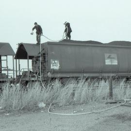 Firemen spraying water onto burning coal in NHTF hoppers at Singleton, NSW, September 1986