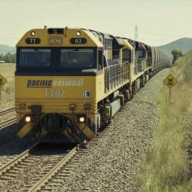 TT02, a 92 class and another TT class wait for a cross at Yarrawa, NSW, January 2017