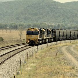 TT02, a 92 class and another TT class approach the up starting signal at Sandy Hollow, NSW, January 2014