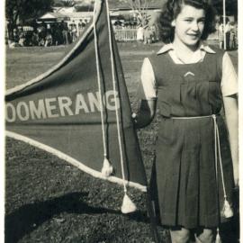 Pat Craig as girl holding "Boomerang" flag